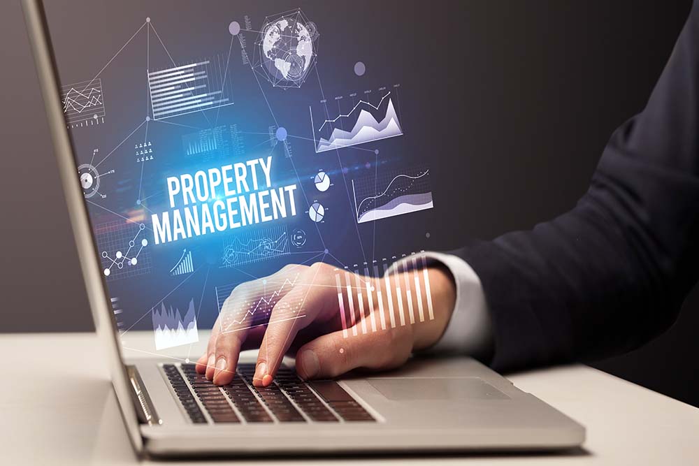 photo of a laptop with property management on the background | two men talking | digital property management